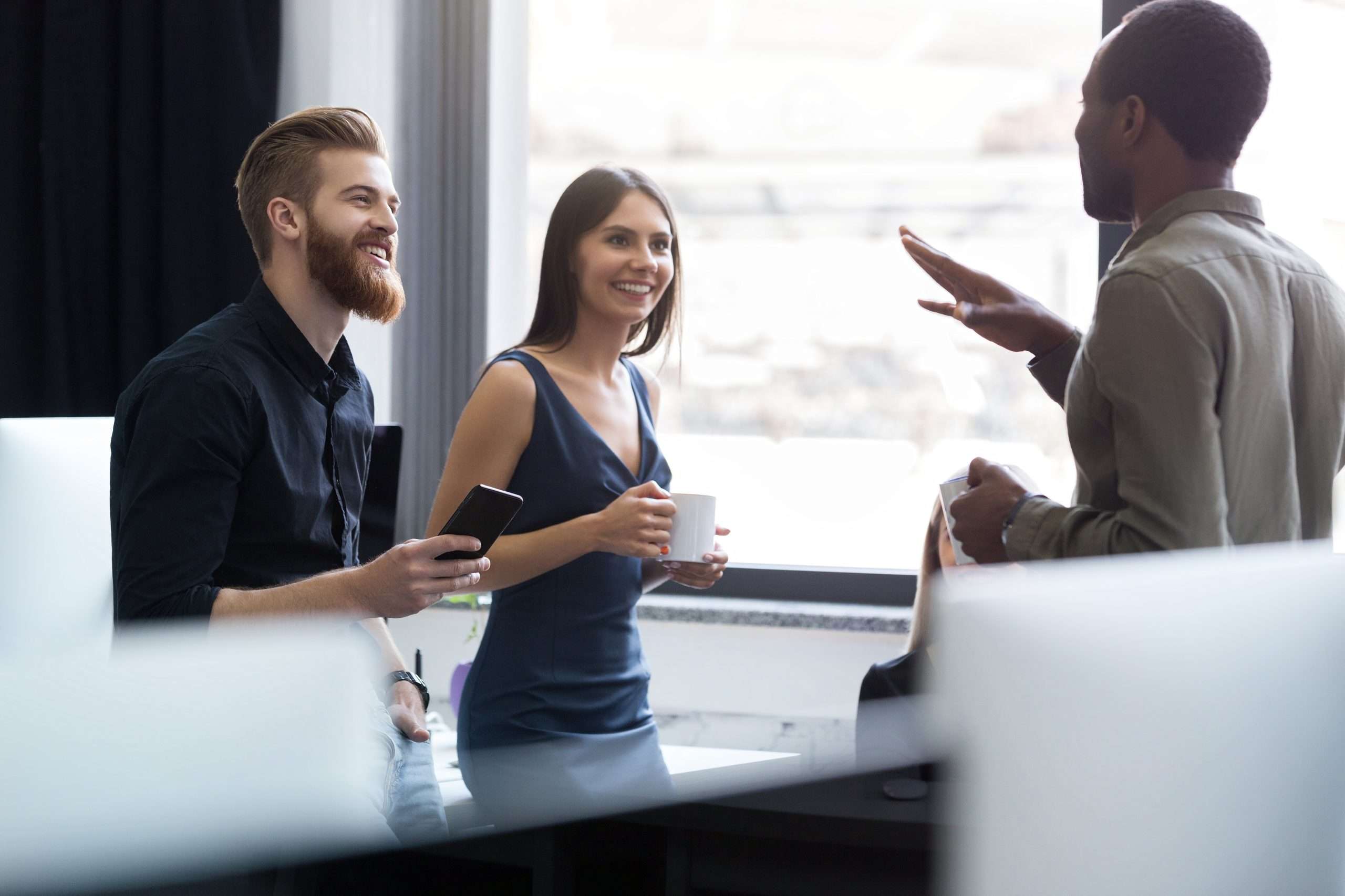 Young afro american man speaking to two of his colleagues